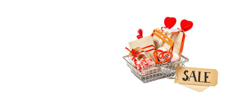Spring Sale concept isolated on white background. Shopping basket with festive gifts and traditional Valentine's Day decor. Trendy hard light, dark shadow. Flat lay, mockup, templateの写真素材