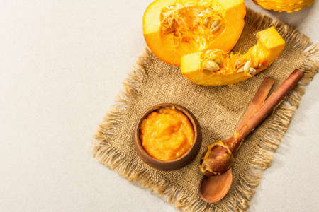 Autumn food cooking concept. Pumpkin puree, whole and cut pumpkins. Traditional fall symbol, stone background, top viewの写真素材