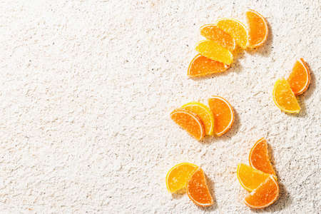 Lemon and orange marmalade. Jelly candies in the form of slices. Traditional sweet dessert, trendy hard light, dark shadow. Putty background, food's flat lay, top viewの写真素材