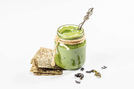 Jarred Kelp puree isolated on white background. Healthy superfood from oceanic seaweed. Ingredient...