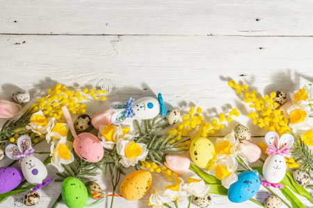 Spring Easter festive background with pastel eggs, cute bunnies, and traditional spring flowers....