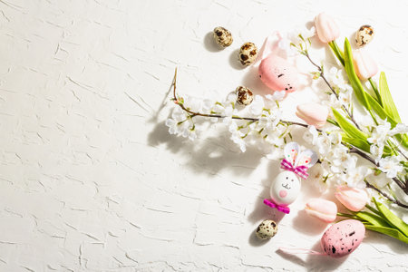 Happy Easter background with blooming cherry, tulips and cute rabbit. Spring flat festive lay,...