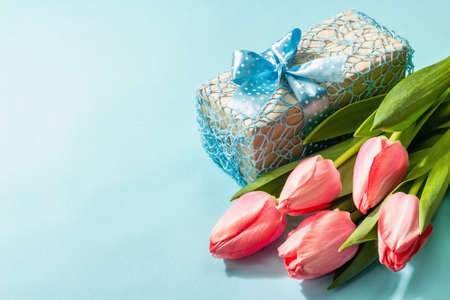 Greeting concept flower composition, a bouquet of pink tulips, and a gift. International Women's,...