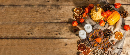 Autumn cozy composition. Scarf, warm mittens, candles, pumpkins, fall decor. Wooden rustic...