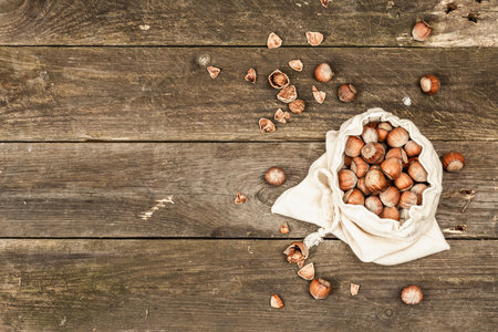 Ripe hazelnuts in shells. Harvest in a linen bag, a healthy ingredient for snacks. Old wooden...