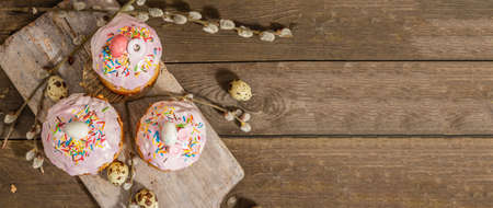 Happy Easter bread. Festive cake with traditional decor. Eggs, willow, trendy hard light, dark shadow. Traditional baking on wooden background, rustic style, banner formatの写真素材