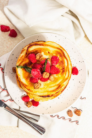 Classic homemade American pancakes with frozen raspberries, hazelnut and mint. Healthy breakfast,...