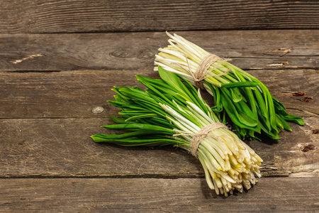 Bunches of a fresh harvest of spring ramson or wild leek. Fragrant spicy leaves on vintage wooden...
