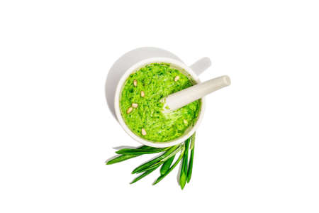 Ramson pesto with olive oil, parmesan, and pine nuts isolated on white background. Bowl of fragrant spread, spicy appetizer, or ingredient for cooking food. A hard light, dark shadow, top viewの写真素材