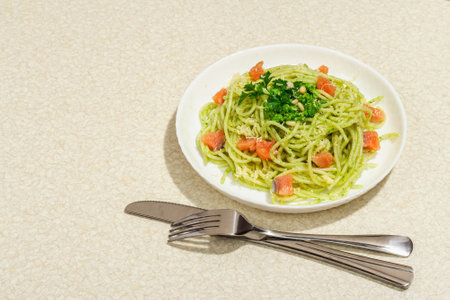 Pasta with salmon, wild leek pesto and parmesan. Fresh spaghetti and greens. Healthy vegan food, trendy hard light, dark shadow. Stone concrete background, copy spaceの写真素材
