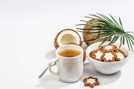 Gluten-free and lactose-free coconut cookies. Homemade healthy pastries, green tea, sunny morning. A trendy hard light, dark shadow, white background, copy spaceの写真素材