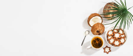 Gluten-free and lactose-free coconut cookies. Homemade healthy pastries, green tea, sunny morning. A trendy hard light, dark shadow, white background, banner formatの写真素材