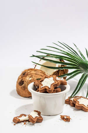 Gluten-free and lactose-free coconut cookies. Homemade healthy pastries, vegan lifestyle. A trendy hard light, dark shadow, white background, copy spaceの写真素材