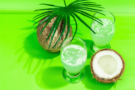 Refreshing summer Coconut martini. Non-alcoholic Margarita cocktail, trendy hard light, dark shadow. Bright green background, top viewの写真素材
