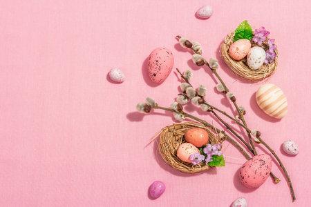Traditional Easter composition - eggs, bird's nests, willow twigs, themed decor. A modern hard light, dark shadow, delicate pink backgroundの写真素材