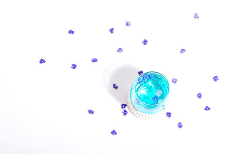 Cold tonic water and blue forget me not flowers on stand isolated on a white background. Springtime...