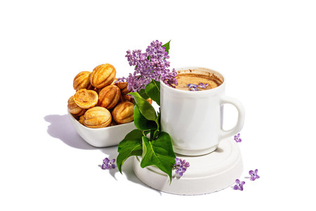 Cup of coffee and cookies in the shape of walnuts with cream filling isolated on a white background....