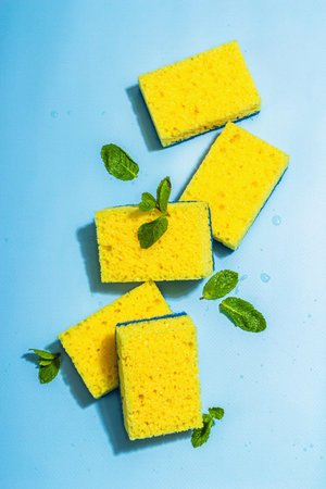 Bright yellow sponges for washing dishes. Organic cleaning concept, minty freshness. A trendy hard...