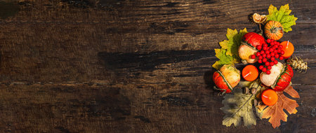 Autumn composition festive on old wooden background. Decorative pumpkin, fall leaves, berries and...