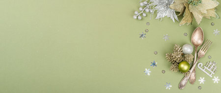 Christmas table setting with traditional accessories on trendy Savannah Green color background. Festive New Year cutlery, hard light, dark shadow, flat lay, banner formatの写真素材