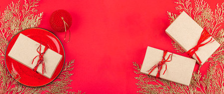 Christmas gift box, surprise concept. New Year background in red and gold colors. Traditional decor, flat lay, minimalistic design, banner formatの写真素材