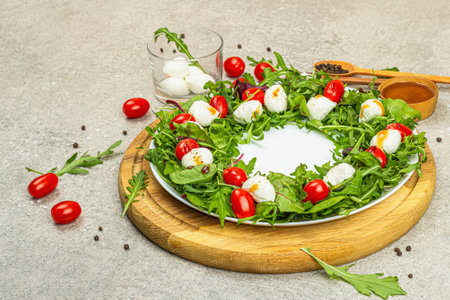 Charcuterie wreath made with mozzarella, cherry tomatoes and arugula. Fashionable snack, festive vegetarian food. Stone concrete background, flat lay, copy spaceの写真素材