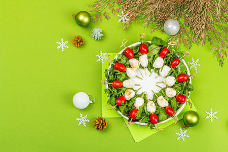 Charcuterie wreath in traditional New Year color design with Christmas decorations. Modern snack, matte green background, flat lay, top viewの写真素材