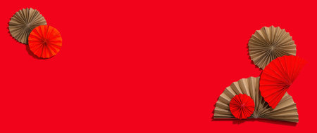 Happy Chinese New Year traditional concept. Oriental asian style paper fans on red background, minimal concept, flat lay, banner format