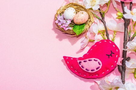 Gentle Easter composition with cherry flowers and handmade felt birds. Decorative eggs and nest,...