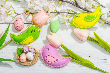 Beautiful Easter background with traditional decor. Flowers, decorative eggs, birds and rabbits. Modern hard light, dark shadow, white boards, flat lay, top viewの写真素材