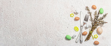 Easter table setting with eggs, rabbits and willow. Traditional symbols festive, greeting card, flat lay. Trendy hard light, dark shadow, plaster background, banner formatの写真素材