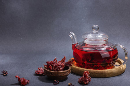 Hibiscus hot tea with dates. Traditional Ramadan Kareem concept snack for Iftar or Suhoor meal on dark stone concrete background. An Arabian sweet treat, hard light, dark shadow, copy spaceの写真素材