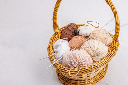 A set of pastel clew of thread for knitting in a basket. Handmade, hobby, crochet concept. Props and...