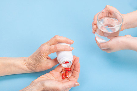 The child gives the woman a glass of water to drink the pills. Treatment, taking vitamins,...