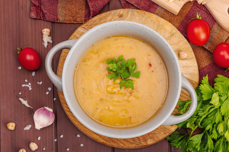 Chickpea-tomato cream soup with fragrant garlic buns. Comfort food, nostalgic mood concept, healthy vegan lunch. Wooden background, flat lay, top viewの写真素材