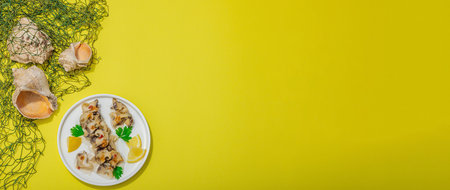 Pickled rapan meat with oil, spices and greens. Healthy seafood rich of omega. Marine decorative prop, hard light, dark shadow, yellow background, banner formatの写真素材