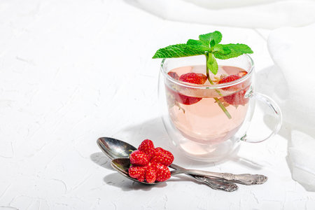 Strawberry tea concept. good morning concept. Teapot, ripe fruits, healthy beverage. Hard light, dark shadow, white background, copy spaceの写真素材
