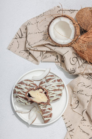 Profiteroles choux pastry buns with coconut cream served in tropical style. Sweet healthy dessert,...