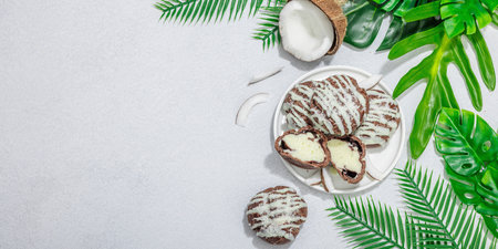 Profiteroles choux pastry buns with coconut cream served in tropical style. Sweet healthy dessert, flat lay, good morning or coffee break concept, banner formatの写真素材