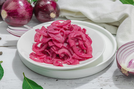 Delicious pickled red onions on white table. Served meal ready to eat, trendy hard light, dark shadow. White wooden background, close upの写真素材