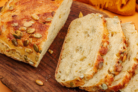 Fresh bread with pumpkin seeds. home baking concept. Autumn decor, pumpkin, fall leaves. Wooden...