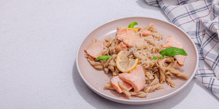 Plant based pasta with salmon, pesto and parmesan cheese. Ready to eat healthy food, served portion on stone table. Hard light, dark shadow, flat lay, banner formatの写真素材