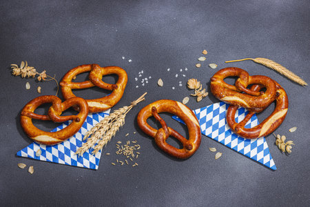 Traditional Oktober fest Pretzels. German festival food concept. Trendy hard light, dark shadow, dark stone concrete background, top viewの写真素材