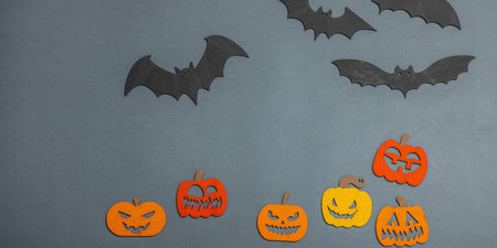 Funny Halloween background. Scary traditional fall pumpkins and flying bats. Festive flat lay, classic autumn style, banner formatの写真素材