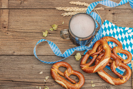 Traditional Oktoberfest set. Pretzels and beer, German festival food concept. Trendy wooden background, top viewの写真素材