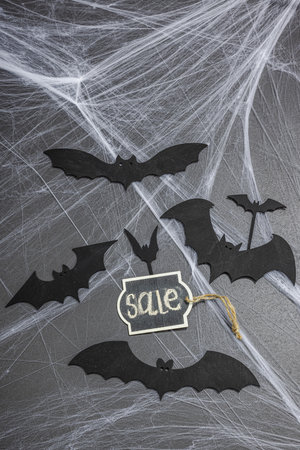 Sale concept, traditional festive composition for Halloween party. Funny seasonal props, homemade autumn decor. Hard light, dark shadow, black stone concrete background, flat lay, top viewの写真素材