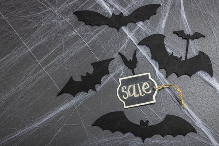 Sale concept, traditional festive composition for Halloween party. Funny seasonal props, homemade autumn decor. Hard light, dark shadow, black stone concrete background, flat lay, top viewの写真素材