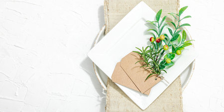 Minimalist table setting. Elegant cutlery, traditional zero waste props, flat lay. Festive cozy mood, empty dishes. Hard light, dark shadow, white putty background, banner formatの写真素材