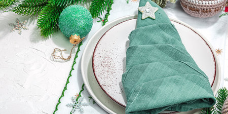 Christmas table setting. New Year cutlery, traditional winter decor, flat lay. Festive cozy mood, minimalist design. Hard light, dark shadow, white putty background, banner formatの写真素材