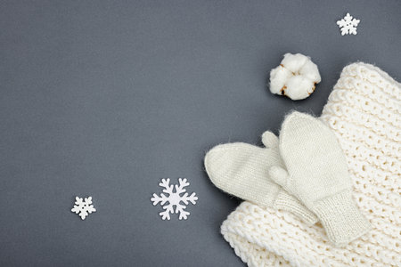 Cozy winter composition. Knitted mittens, warm scarf, traditional Christmas decoration, New Year festive mood. Gray background, flat lay, top viewの写真素材